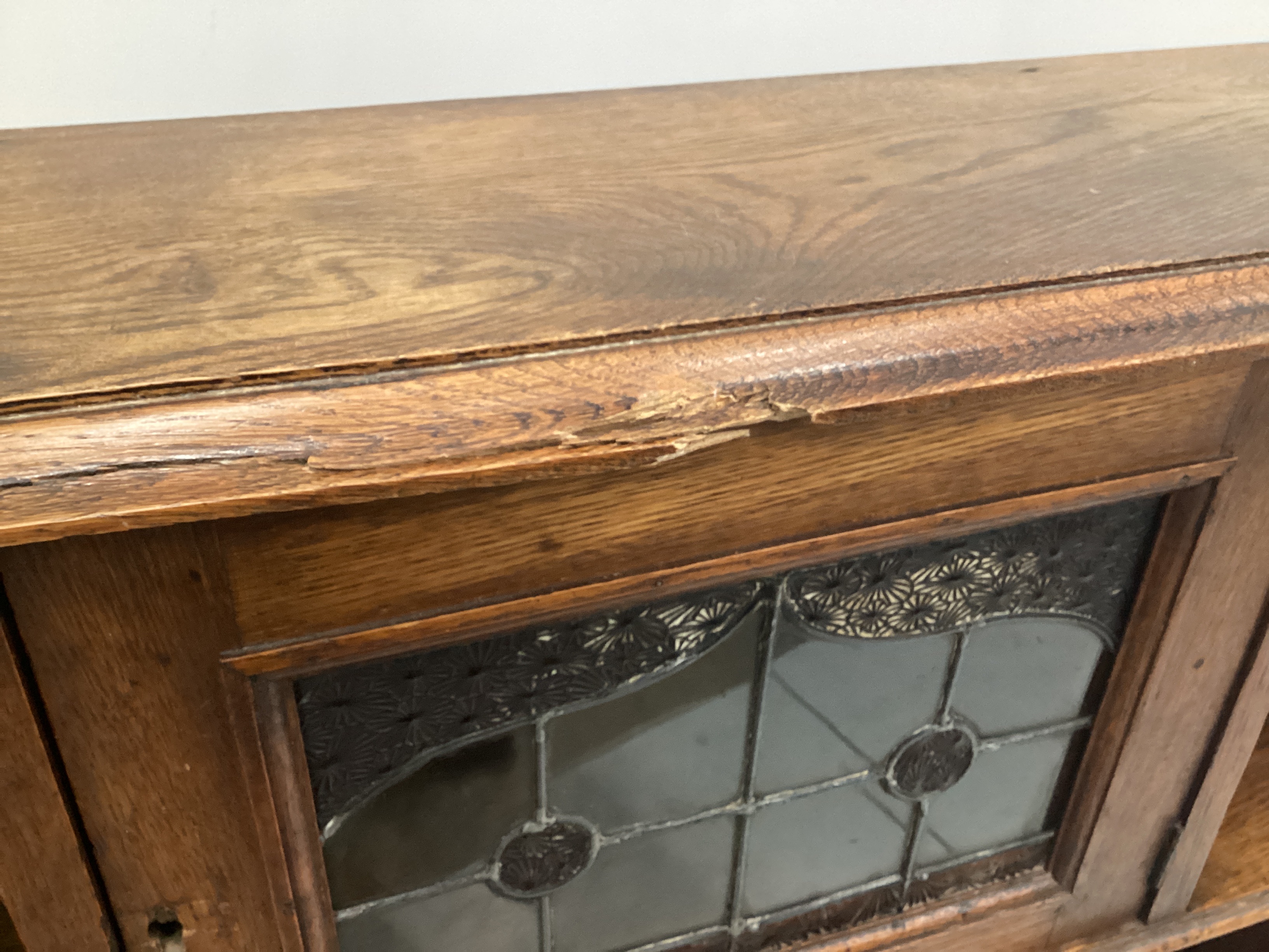 An Arts and Crafts oak open bookcase with leaded glazed door, width 102cm, depth 25cm, height 104cm